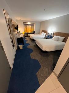Microtel Inn & Suites by Wyndham Charlotte/Northlake في تشارلوت: غرفة فندقية بسريرين واريكة