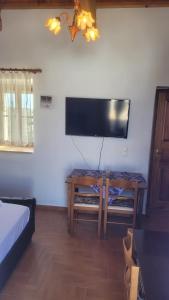 ein Wohnzimmer mit einem TV und einem Tisch mit einem Bett in der Unterkunft KASTRI in Kýthira