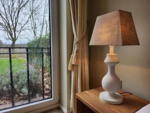 a lamp sitting on a table next to a window at Landhuis de heibloem in Heythuysen