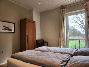 een slaapkamer met twee bedden en een raam bij Landhuis de heibloem in Heythuysen +137 foto's