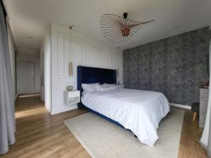 1 dormitorio con 1 cama blanca grande y cabecero azul en Maison moderne bord de seine à Giverny en Saint-Pierre-la-Garenne