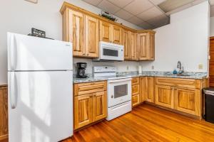 a kitchen with wooden cabinets and a white refrigerator at Hornet Lodge 