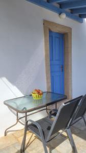 ein Glastisch und Stühle mit einer Obstschale darauf in der Unterkunft KASTRI in Kýthira