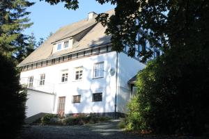 una casa blanca con techo de gambrel en Haus Dupont en Winterberg