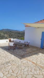 a patio with two benches and a table on a building at KASTRI in Kythira