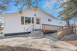 a white house with a staircase in front of it at Farmhouse Ranchette - Horses Welcome in Belle Fourche