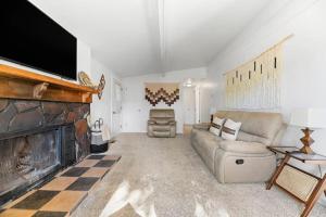 sala de estar con sofá y chimenea en Home at L Rancho, en Spearfish