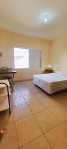 - une chambre avec un lit, un bureau et une fenêtre dans l'établissement Hospedagem Iolanda, à Diamantina