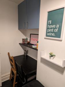 a kitchen with a black table and a sign on the wall at Studio Apartment 5 mins walk to city, FREE WIFI AND PARKING in Cardiff