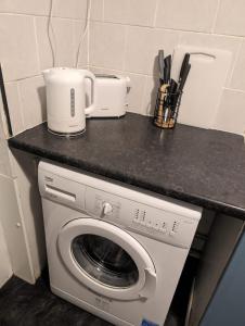 a washing machine with a counter on top of it at Studio Apartment 5 mins walk to city, FREE WIFI AND PARKING in Cardiff