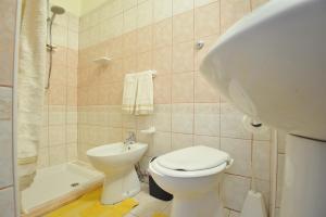 a bathroom with a white toilet and a sink at Apartments Baunei in Baunei