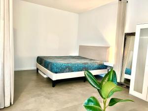 Valley of Business Dortmund - Apartment w Garden - Phoenix-See في دورتموند: غرفة نوم مع سرير وزرع الفخار