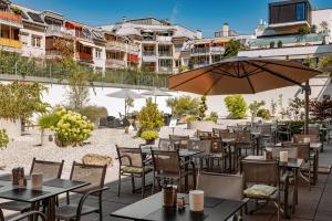 an outdoor restaurant with tables and chairs and an umbrella at Altstadt Hotel Hofwirt Salzburg in Salzburg