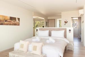 a bedroom with a large white bed with white pillows at Living Stone - Beryl in Athens