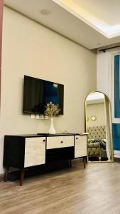 uma sala de estar com televisão e espelho em Luxury apartment in Gold Crest Mall 1 bed em Lahore