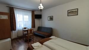 ein Schlafzimmer mit einem Bett, einem Stuhl und einem Tisch in der Unterkunft Pensiunea Casa Sighisoreana in Sighişoara