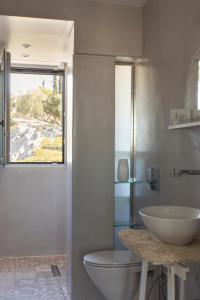 baño con lavabo y aseo y ventana en Living Stone - Beryl en Athens