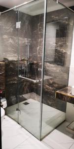 a shower with a glass door in a bathroom at Luxury apartment in Gold Crest Mall 1 bed in Lahore