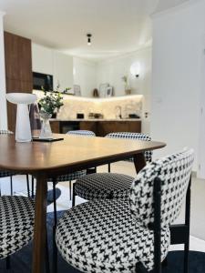 a wooden table and chairs with a kitchen in the background at D26 Luxury Suites in Budapest