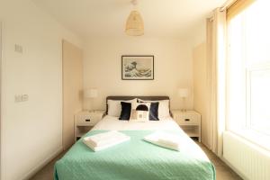 ein Schlafzimmer mit einem Bett mit einer grünen Decke in der Unterkunft Crescent House Apartments in Telford