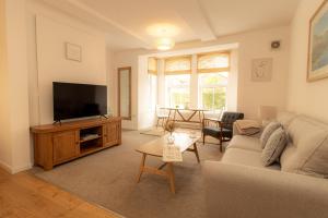 a living room with a couch and a television at Crescent House Apartments in Telford