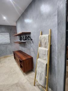 Zimmer mit einem Holztisch und einem Regal mit Handtüchern in der Unterkunft Vetho House in Ballito