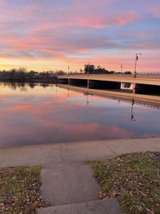 a body of water with a bridge in the background at Bridge Inn Tomhawk - 2nd Floor, 1 King Size Bed, Balcony, River View in Tomahawk