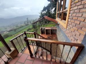 balkon z ławką i stołem w budynku w obiekcie Cabaña Mirador, las Acacias de Teli w mieście Ventaquemada