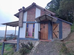 una pequeña casa sentada en la cima de una colina en Cabaña Mirador, las Acacias de Teli en Ventaquemada