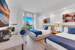 Una habitación de hotel con dos camas y balcón. en Modern Resort with Balcony - Near Beach - Pool, en Hallandale Beach