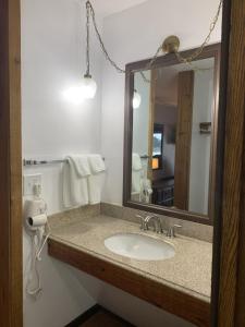 a bathroom with a sink and a mirror at Bridge Inn Tomahahwk - Room 106 ,1 King Size Bed,1 Recliner, Walkout, River View in Tomahawk