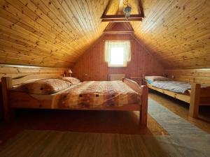 Chatka Hanka في تيرشوفا: غرفة نوم بسريرين في كابينة خشبية