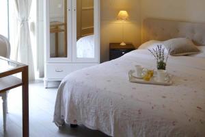sypialnia z białym łóżkiem z tacą z 2 kubkami i kwiatami w obiekcie Nice Garden Hotel w Nicei