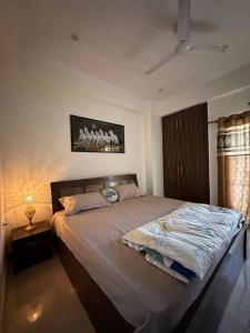 een slaapkamer met een groot bed en een lamp bij Your cozy home in Dehradun