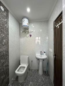 een badkamer met een toilet en een wastafel bij Your cozy home in Dehradun