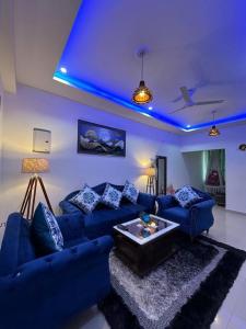 een woonkamer met blauwe plafonds en blauwe verlichting bij Your cozy home in Dehradun