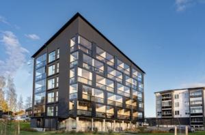 un grand bâtiment noir avec des fenêtres en verre dans l'établissement Modern apartment near Tampereen Messukeskus, with own private and free parking, à Tampere