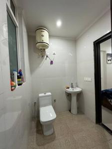 een witte badkamer met een toilet en een wastafel bij Your cozy home in Dehradun