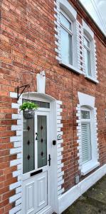 um edifício de tijolos com uma porta com um vaso de plantas em Bloom19 Traditional Belfast Entire house 10 mins from city centre em Belfast