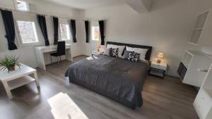 a bedroom with a bed and a desk and windows at Ferienhaus Müller Bauernhaus in Sankt Stefan ob Stainz
