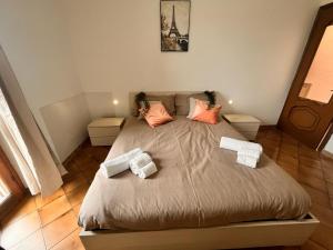 een slaapkamer met een groot bed met kussens erop bij Modigliani house posizione strategica bilo in Bruino