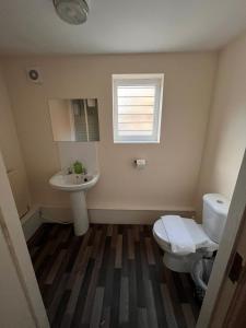 a bathroom with a toilet and a sink and a window at Guest House 5 Beds 4 En-suites Middlesbrough in Middlesbrough