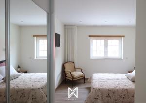 una camera con due letti e uno specchio di MyStay - Oliveira Douro House a Peso da Régua