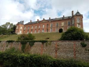 a large brick building on top of a hill at Le petit nid de Muzy in Muzy