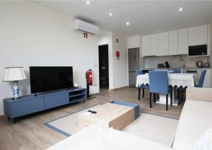 een woonkamer met een tv en een keuken bij MyStay - Oliveira Douro House in Peso da Régua