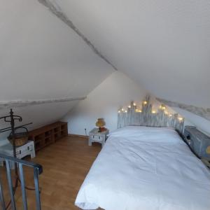 a bedroom with a white bed with lights on it at Le petit nid de Muzy in Muzy