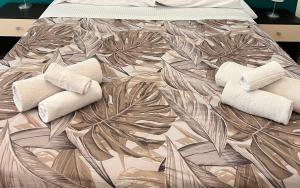 Una cama con dos toallas con un patrón de hojas. en Casa Levante en Cefalú
