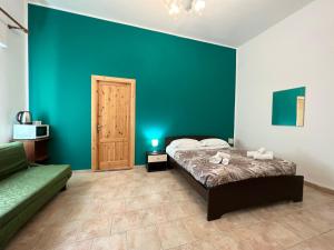 1 dormitorio con cama y pared azul en Casa Levante en Cefalú