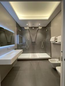 a bathroom with a shower and two sinks and a mirror at Domus Camillus in Milan