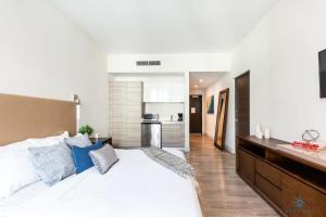 1 dormitorio con 1 cama blanca grande con almohadas azules en Hot tub & Rooftop pool- Near Beach, en Hollywood